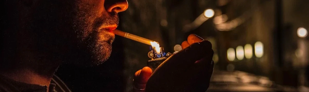 Fumeur allumant une cigarette avec un briquet tempête